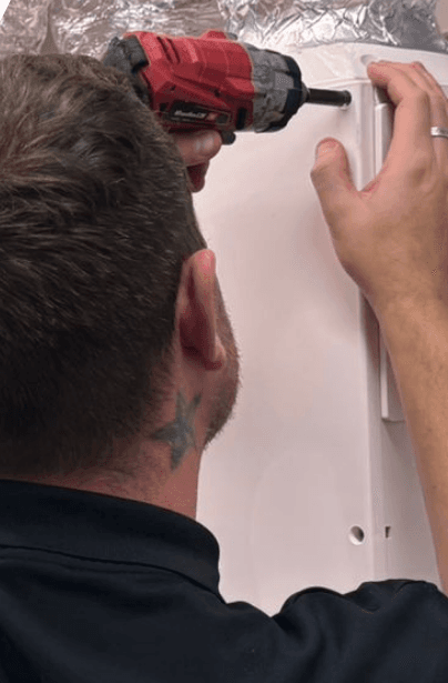 Built Environment Technology engineer installing an MVHR unit